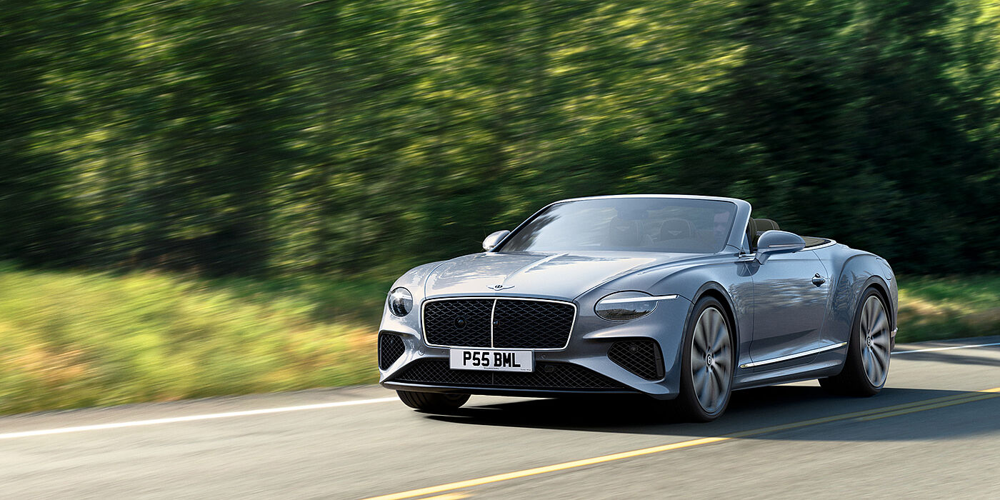 Bentley Douglas New Bentley Continental GTC convertible front view in Silverlake paint with 22 inch ten spoke wheels, driving dynamically on a country road