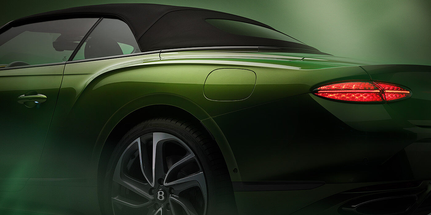 Bentley Douglas Bentley New Continental GTC Speed rear haunch and tail lamp in Tourmaline Green paint and dark tint brightware with black hood up and illuminated head lamps